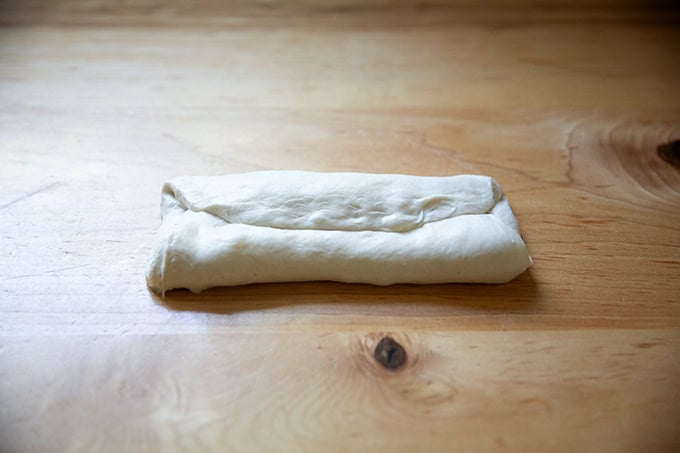 A round of baguette dough folded envelope style.