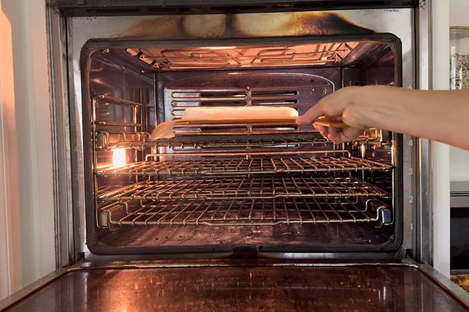 Shimmying a baguette onto a Baking Steel in an oven.