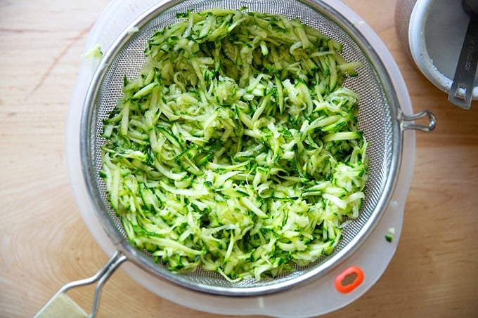 Shredded zucchini in a colander.