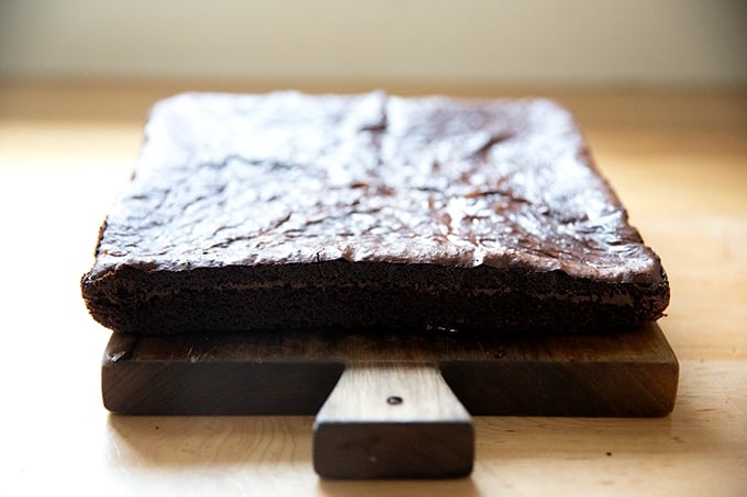 A sideview of just-baked brownies on a cutting board.