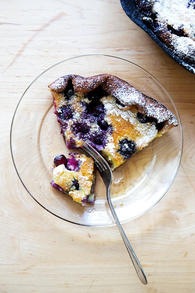 A slice of a blueberry Dutch baby on a plate.