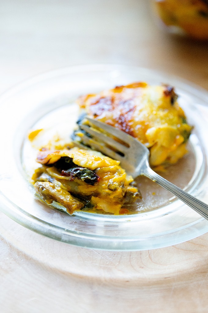 A slice of butternut squash lasagna with greens and mushrooms.