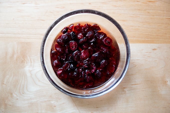 A bowl of dried cherries soaking in a bowl with vinegar.