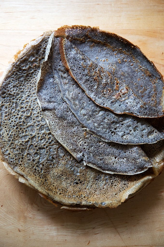 A stack of cooked buckwheat crepes on a plate.