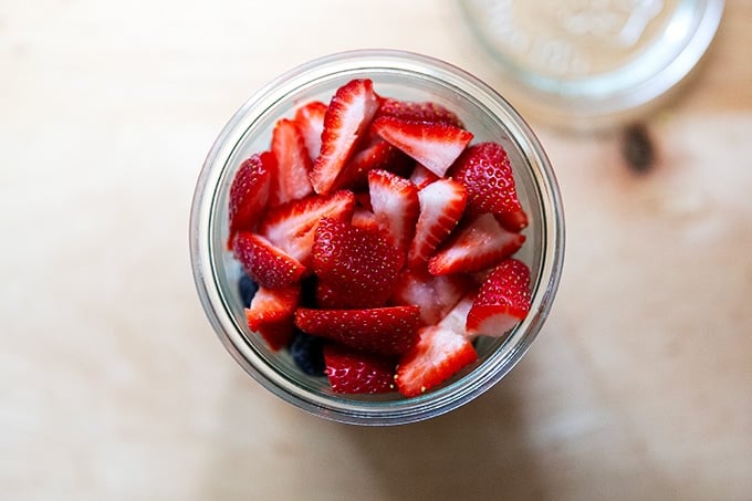 A Weck jar filled with overnight chia oats with strawberries and blueberries on top.