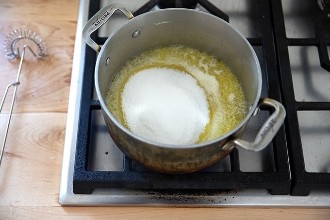 A pot on the stovetop filled with butter and sugar.