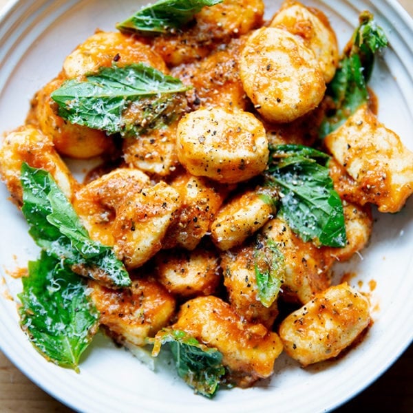 A bowl of ricotta gnocchi tossed in tomato sauce, basil, and parmesan.