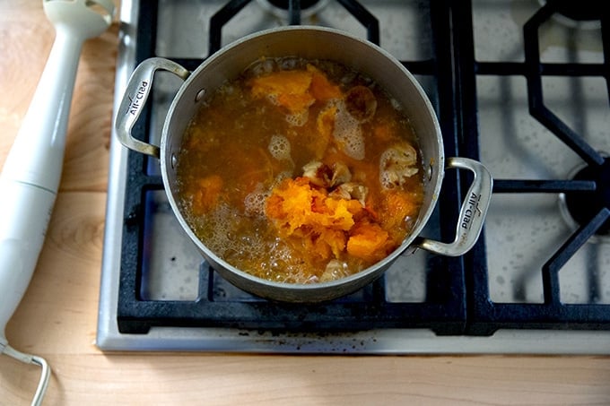 A pot of ready-to-be purèed roasted butternut squash and garlic soup.