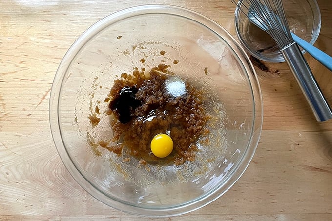 Adding the egg, vanilla, and salt to the cookie batter.