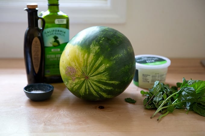 Ingredients to make watermelon feta salad on a countertop.