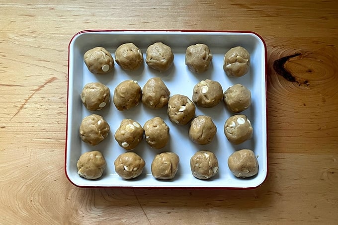 Portioned cookie dough balls on a small tray. 
