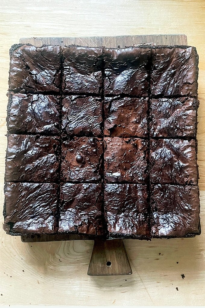 Freshly baked and cut shiny-topped brownies.