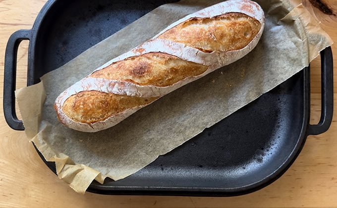 A fully baked baguette in a Challenger Bread Pan. 