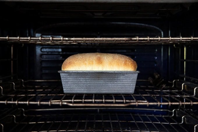 A loaf of sourdough discard toasting bread baking in the oven.