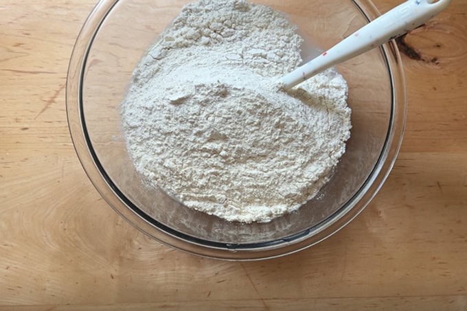 A bowl of water, salt, sourdough starter and flour, not yet mixed together.  - 24