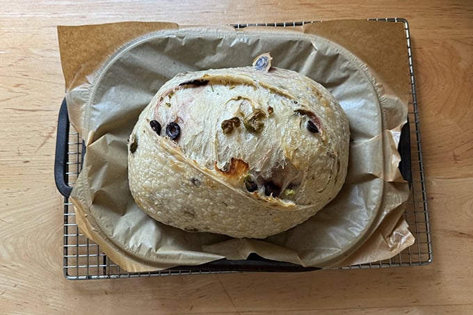 A parbaked loaf of rosemary-olive sourdough bread. - 48