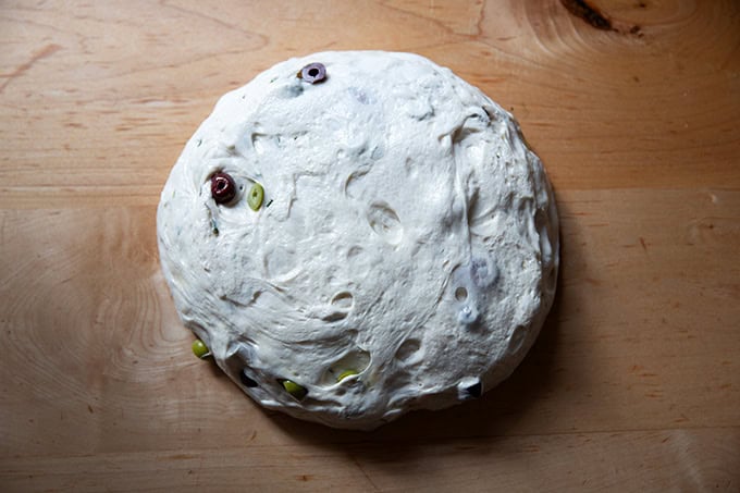 Rosemary-olive sourdough dough turned out onto a countertop. - 40