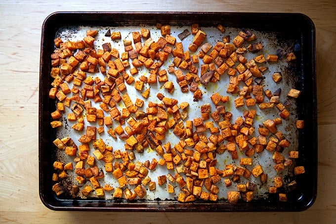 Roasted sweet potato cubes on a sheet pan, rested for a few minutes then tossed with a spatula. - 34