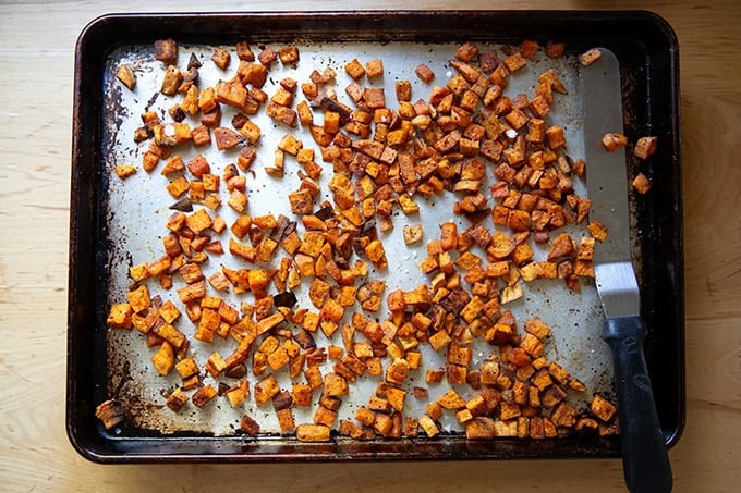 Roasted sweet potato cubes on a sheet pan. - 35