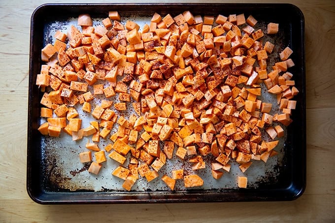 Cubed sweet potatoes tossed with melted coconut oil, salt, and Aleppo pepper. - 32