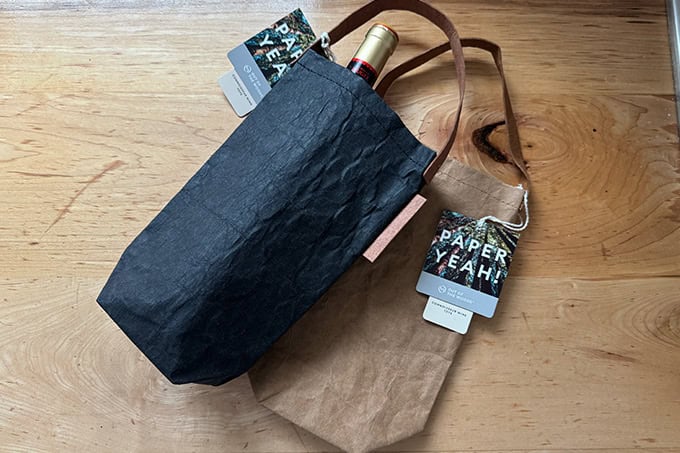 Paper wine totes holding a bottle of wine.