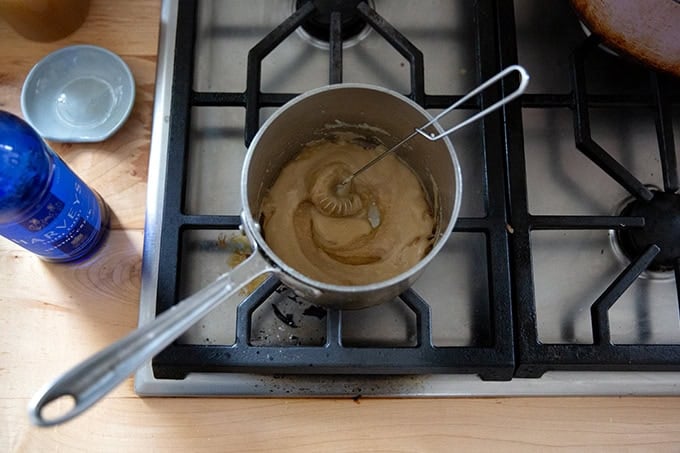A roux in a small saucepan on the stovetop with Sherry added. - 47