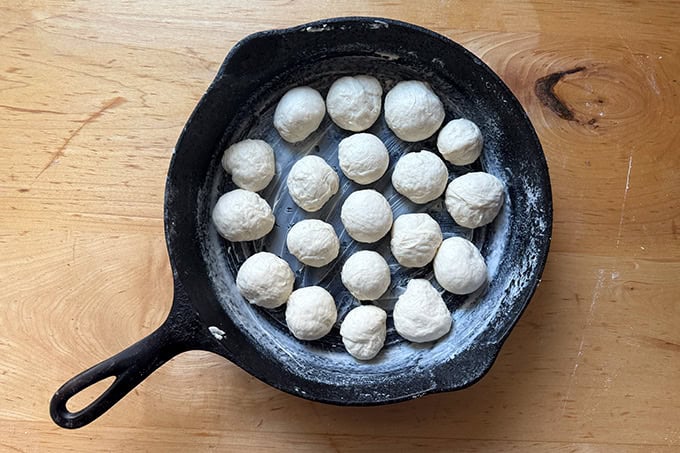 Monkey bread dough balls in a cast iron skillet. - 70