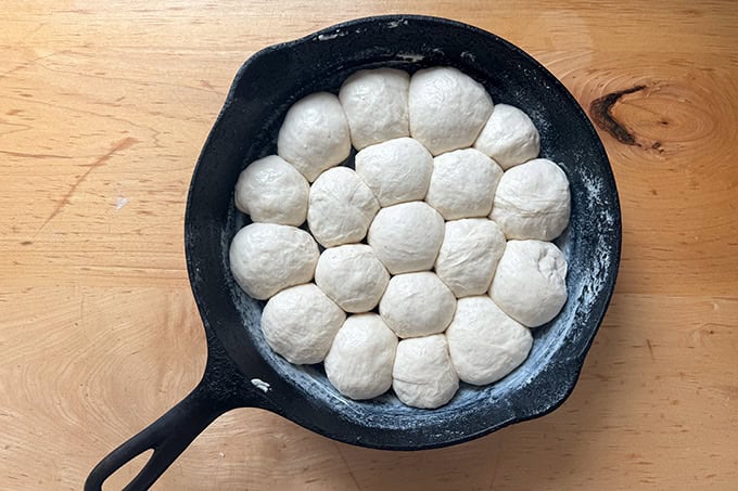 Monkey bread dough balls risen in a 9-inch cast iron skillet. - 71
