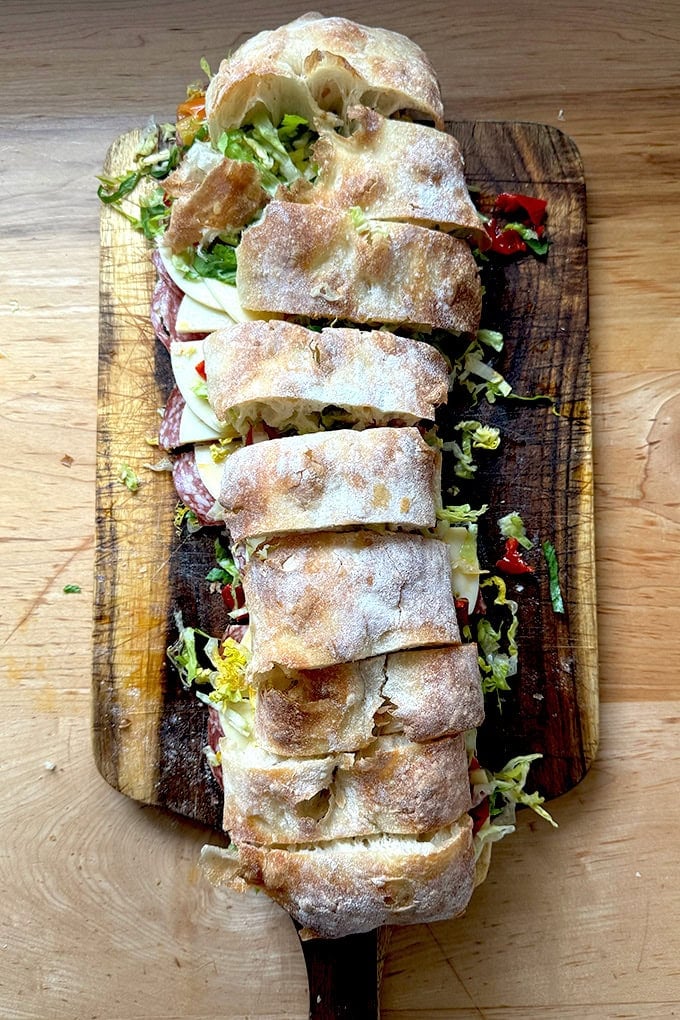 A giant sandwich on a cutting board.