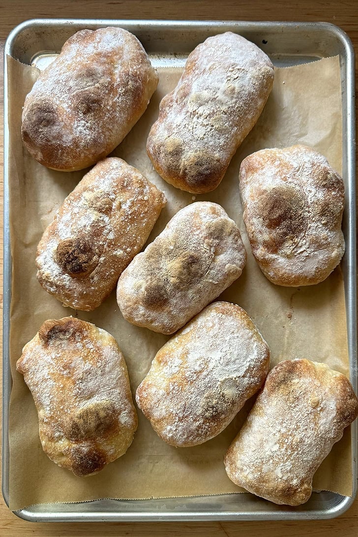 Eight just-baked Overnight Sandwich Rolls on a sheet pan.
