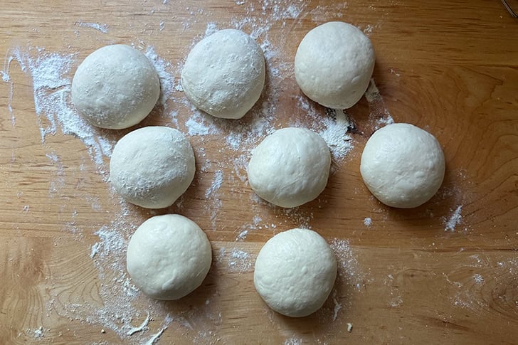 Eight balled up portions of dough to make Overnight Sandwich Rolls.