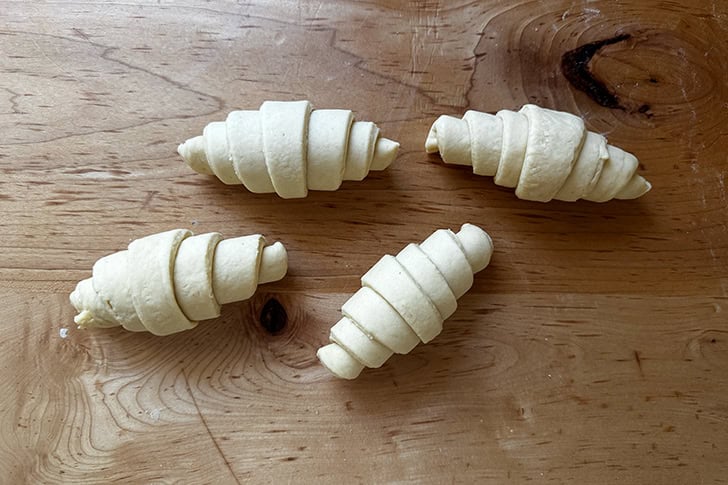 Four unbaked croissants, just coiled up.