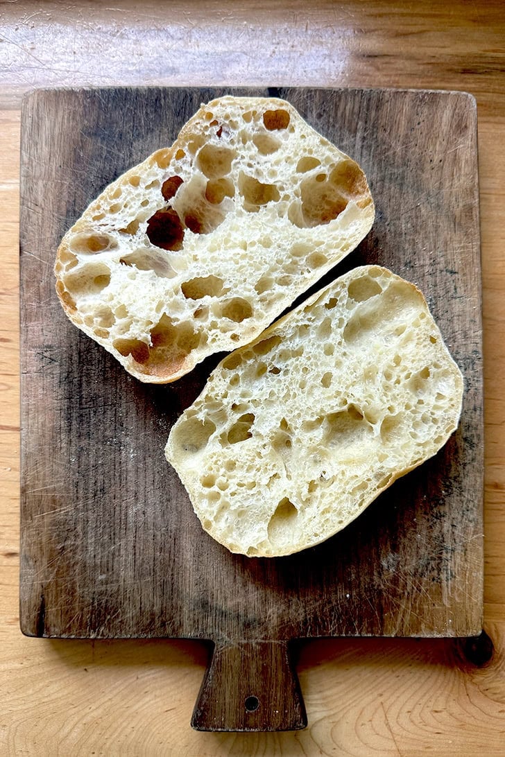 A halved Overnight Sandwich Roll on a cutting board.