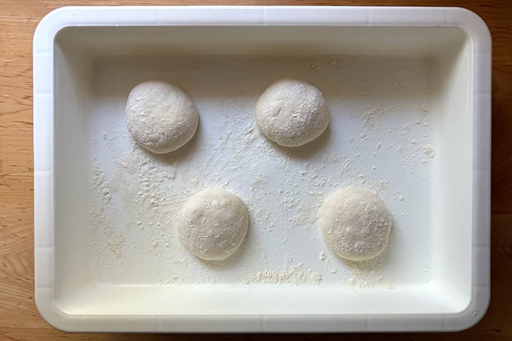 Four balled up portions of Overnight Sandwich Roll dough in a DoughMate.