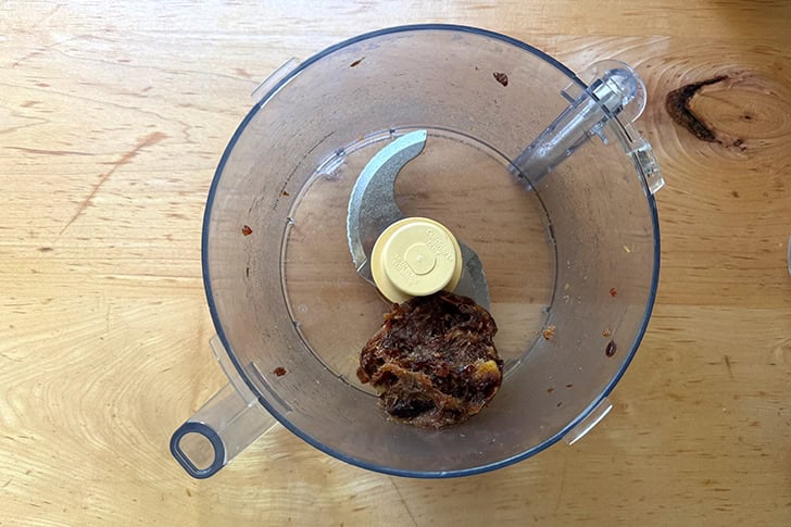 A food processor filled with puréed dates.
