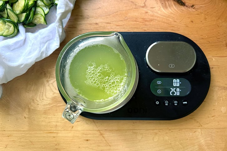 A liquid measure on a scale filled with zucchini water.