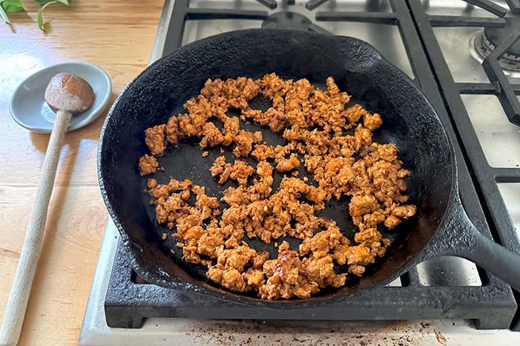A cast iron skilled holding browned chorizo.
