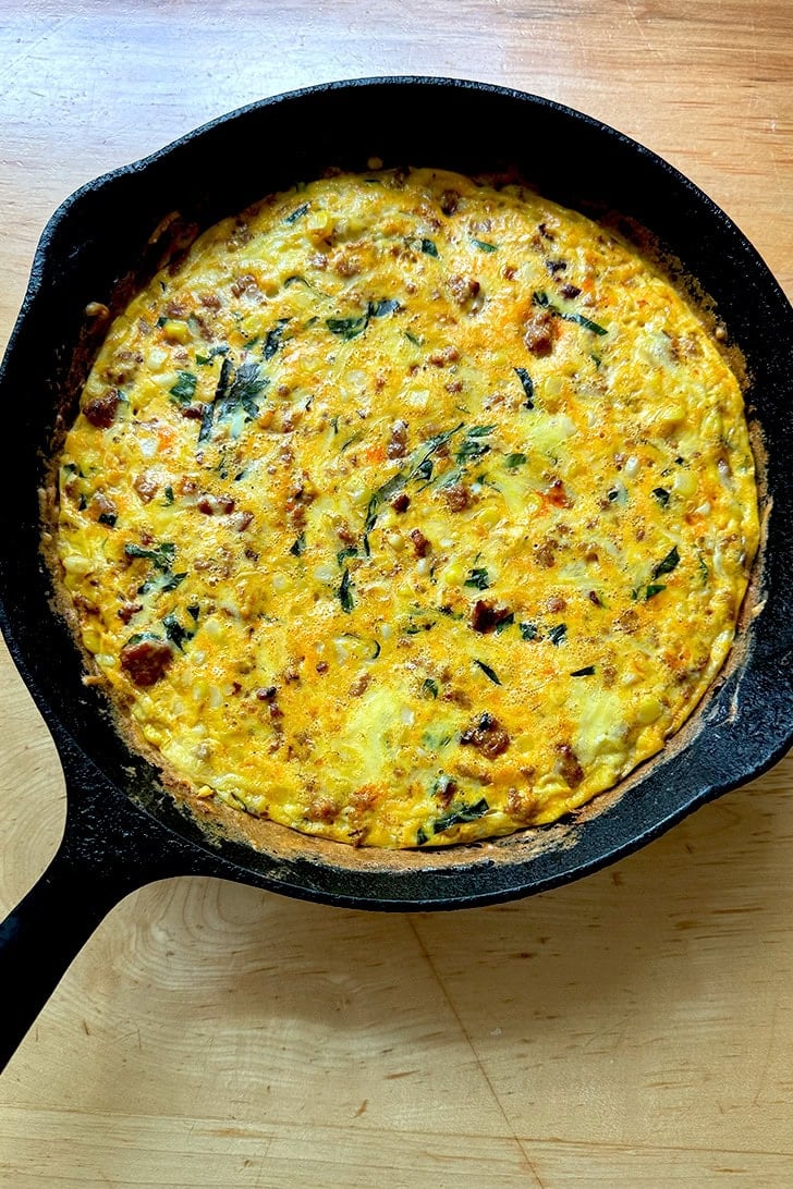 A just-baked frittata in a cast iron skilled.