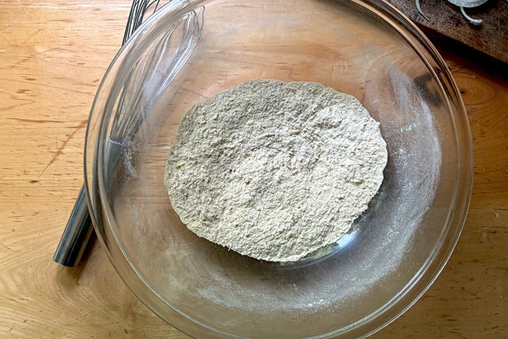 The dry ingredients for Scarpaccia whisked together in a large glass bowl.