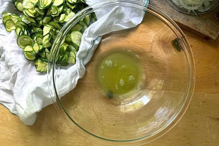 A large glass bowl filled with a small amount of zucchini water.